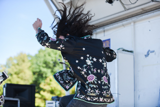 Stephen leaps during his set, throwing his long, curly hair into the air. 